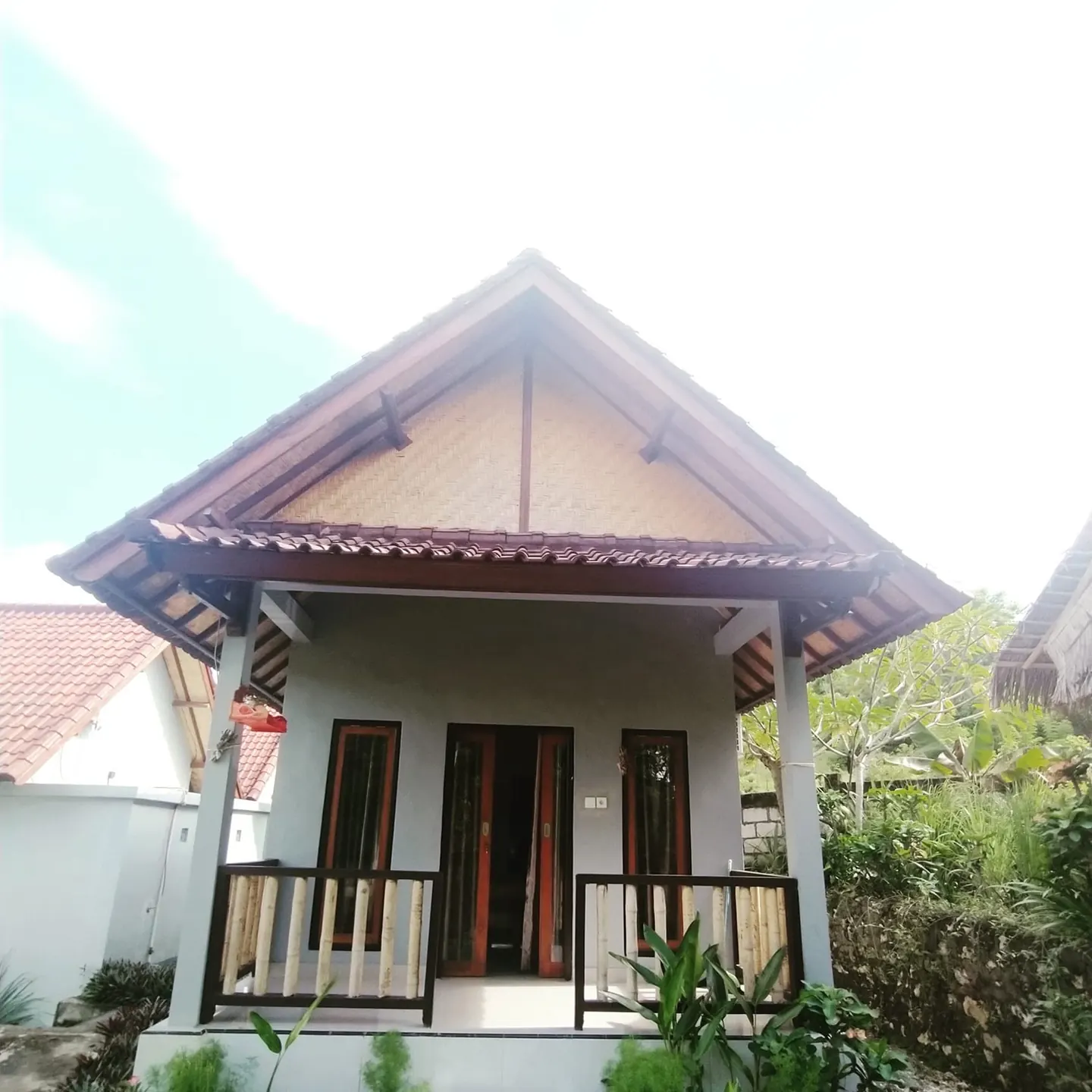 Front of a small bungalow with a porch and twin doors