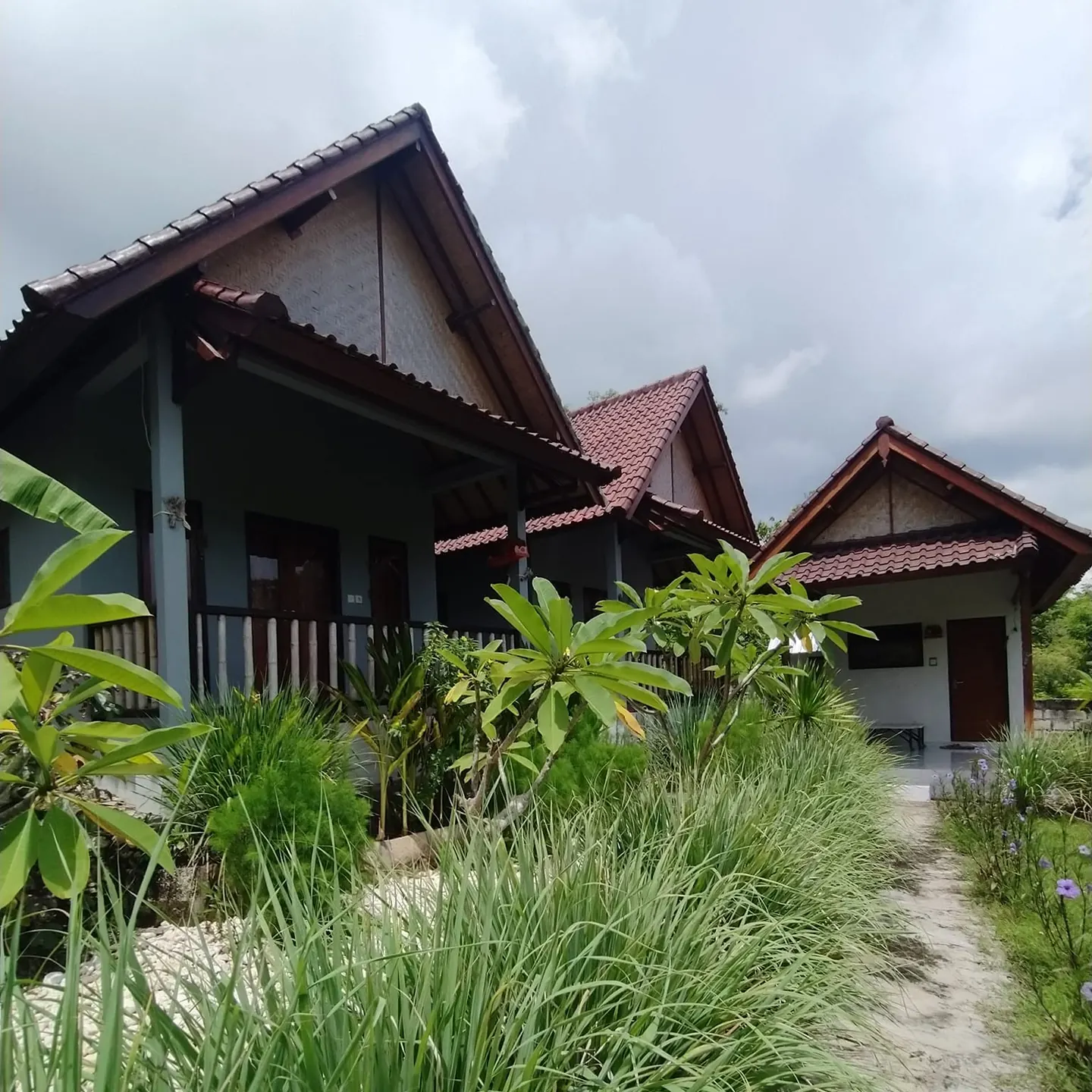 Three tiled roofs in a row along a grassy garden path