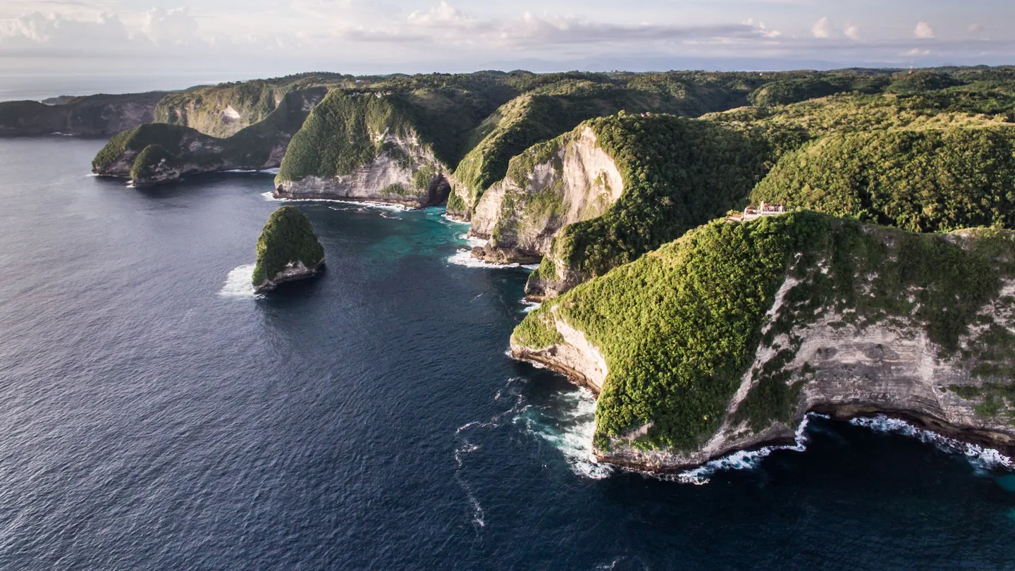 Green cliffs of Nusa Penida above a dark blue sea